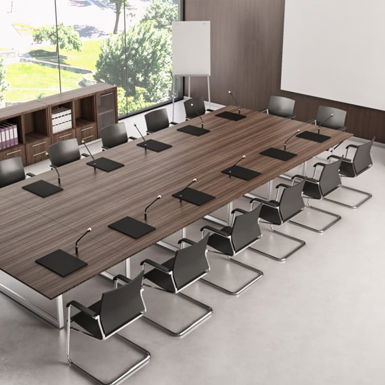 The Cubiko Conference room features a spacious wooden table surrounded by 12 sleek black chairs, with microphones and notepads neatly arranged. A whiteboard and file shelves provide functional accents, while large windows reveal scenic green views, creating a modern and inviting atmosphere. Studio Office Cyprus