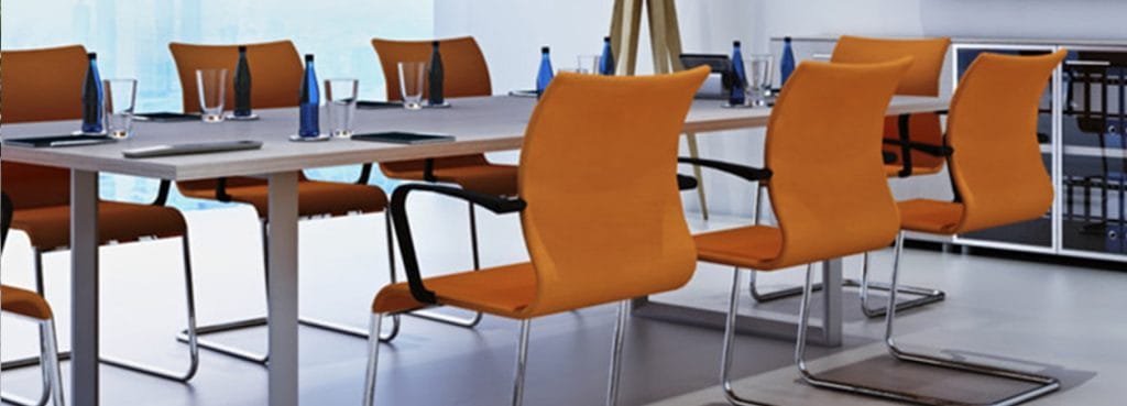 Cubiko Conference table with orange chairs, perfect for collaboration spaces, modern design with practical functionality.
