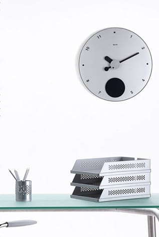 Modern desk featuring Clocks - Desk Accessories. Minimalist white clock and metal desk organizer on a glass surface.