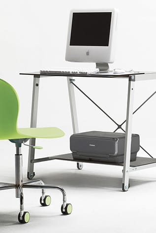 Modern desk setup with a green chair and computer. Shop Desk Sets for your workspace.