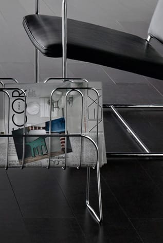 Chrome desk sets organizer with magazines and chair in background.