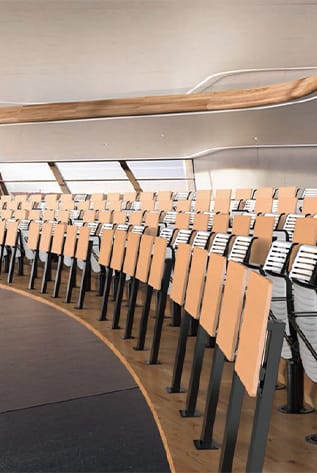 Curved Amphitheater seating in light wood and black metal, designed for comfort and clear sightlines.