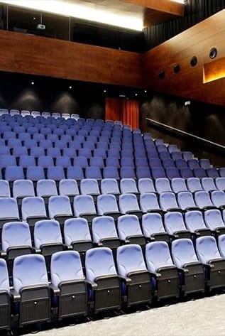 Rows of blue cinema seating in a modern theater.