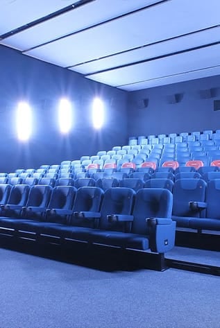 Comfortable blue Cinema seating with cup holders and ergonomic design.