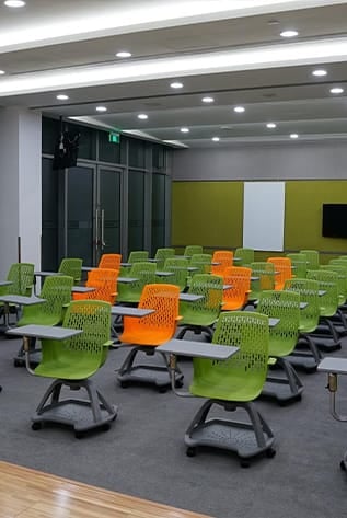 Classroom with modern green and orange chairs for Higher Education.