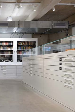 White Museum Storage Solutions: Cabinets, drawers, and glass display case for artifact preservation.