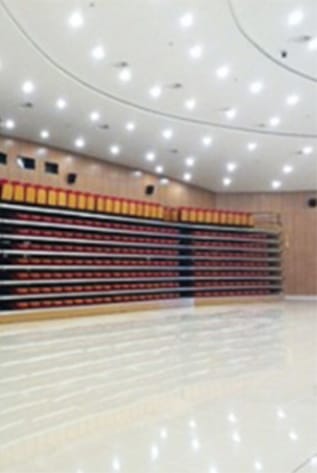 Auditorium seating. Rows of red and gold seating. Seating and Staging Solutions for venues, theaters, and schools.