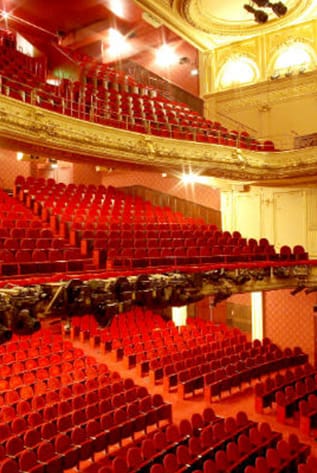 Opulent Theater: Red velvet seats in a classic, tiered auditorium.