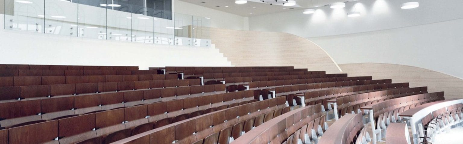 Spacious lecture halls with tiered seating and integrated writing surfaces. Ideal for educational environments.