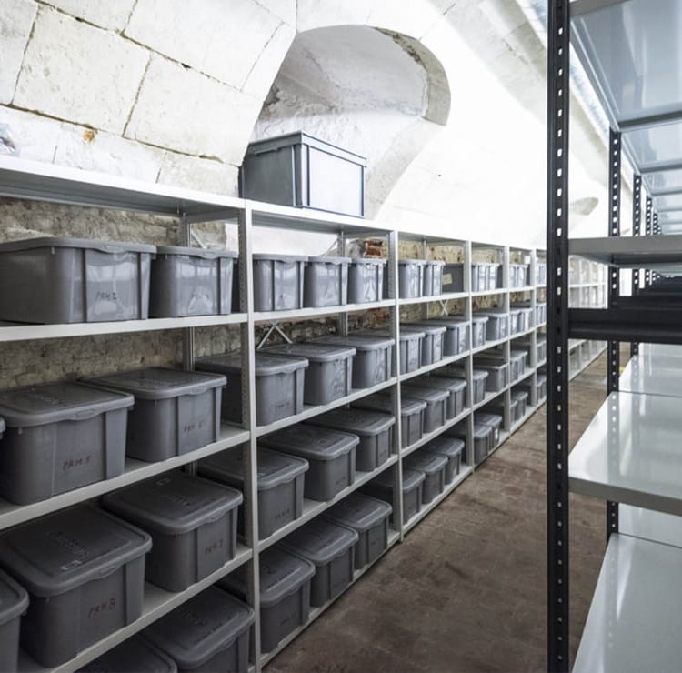 Gray bins on metal shelves. Warehouse Storage Solutions for efficient space.