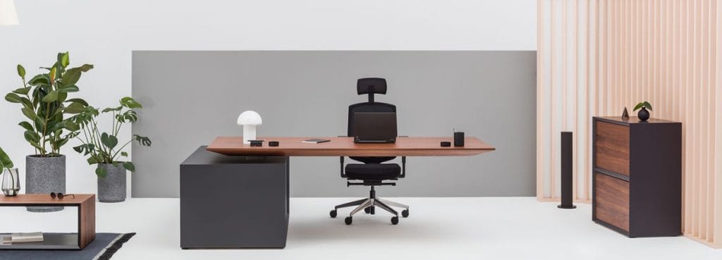Modern Gravity desk by MDD with wood top, black base, and ergonomic chair in a bright office setting.