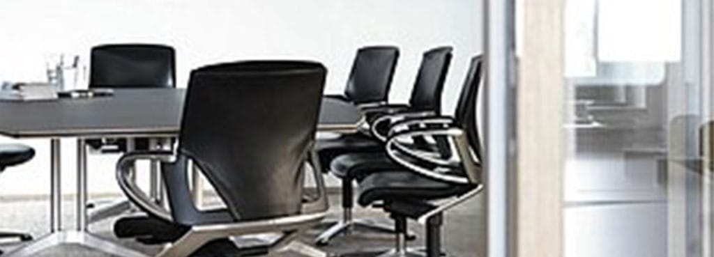 Modern conference room featuring black leather Modus chairs and a sleek table.
