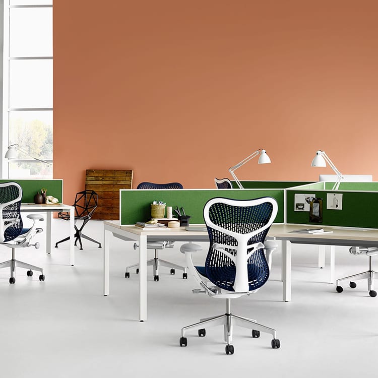 Modern office featuring the ergonomic Mirra 2 chair with a white frame and blue seat.