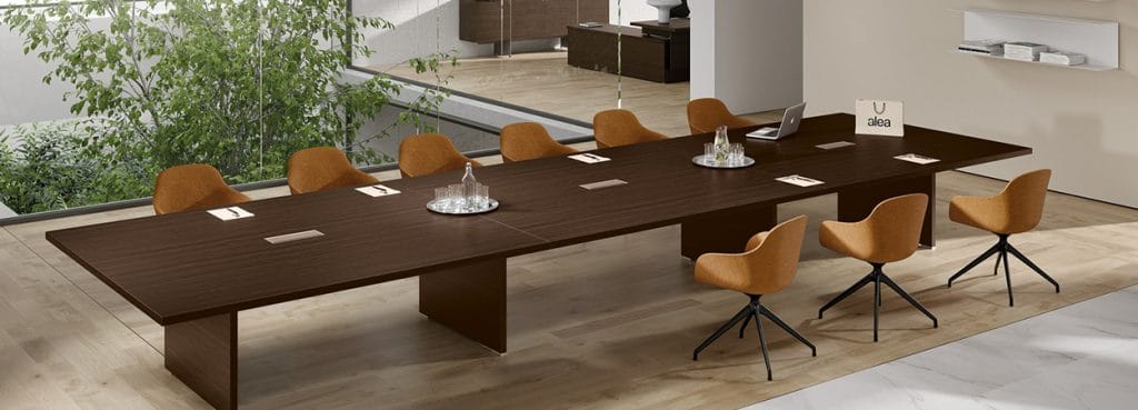 Modern Odeon Conference Table with a dark wood finish and tan chairs in a bright meeting space.