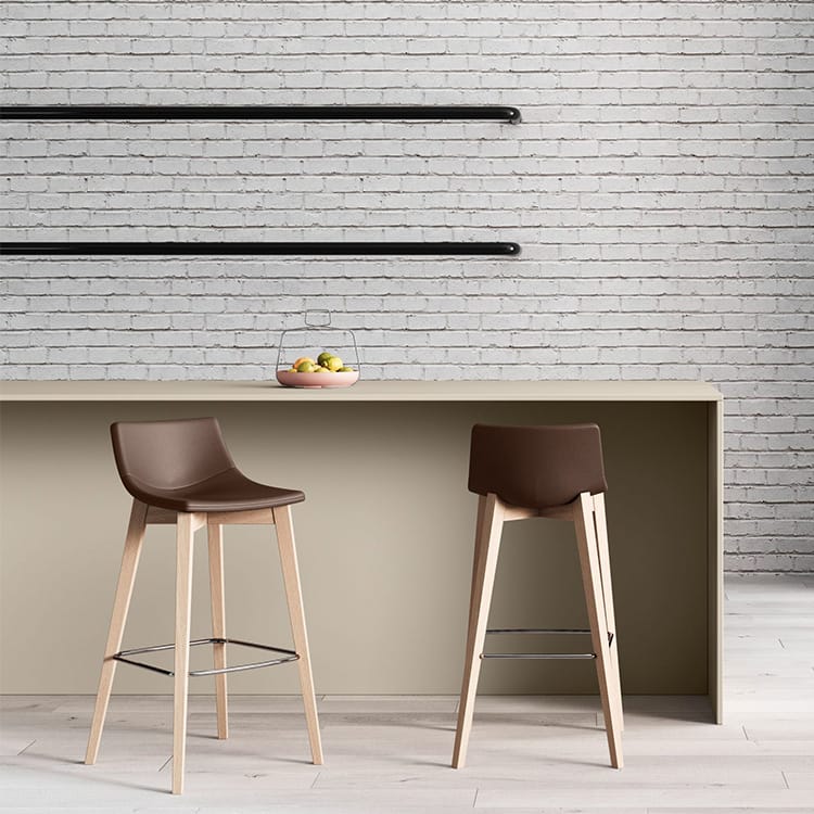 Two Superotto Stools with brown seats and light wood legs at a counter.