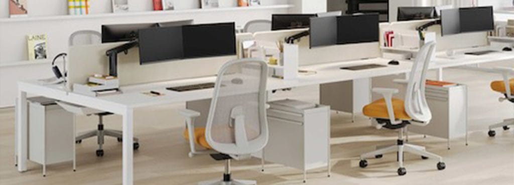 Modern office featuring Layout Studio desks, white frames, dual monitors, and ergonomic chairs.