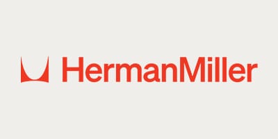 Λογότυπο Herman Miller. Κόκκινο κείμενο και εικονίδιο καρέκλας σε ανοιχτόχρωμο φόντο.