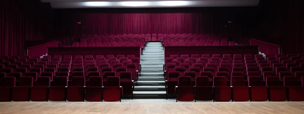 Empty amphitheatre with red velvet seats and curtains, furniture.