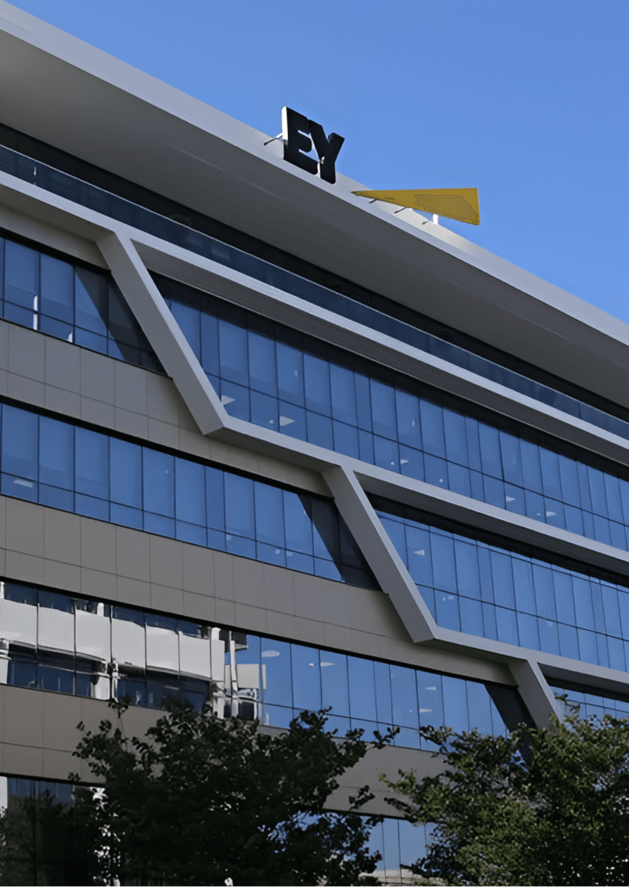Το κτίριο γραφείων της EY στη Λευκωσία, Κύπρος, με σύγχρονη αρχιτεκτονική, γυάλινα παράθυρα και το λογότυπο της EY στην κορυφή.