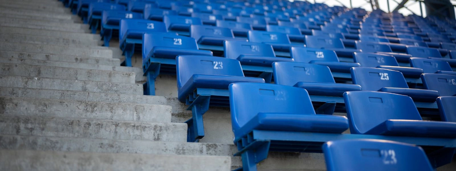 Σειρές από μπλε αριθμημένα καθίσματα σταδίου, που δείχνουν ευέλικτες διατάξεις θέσεων.