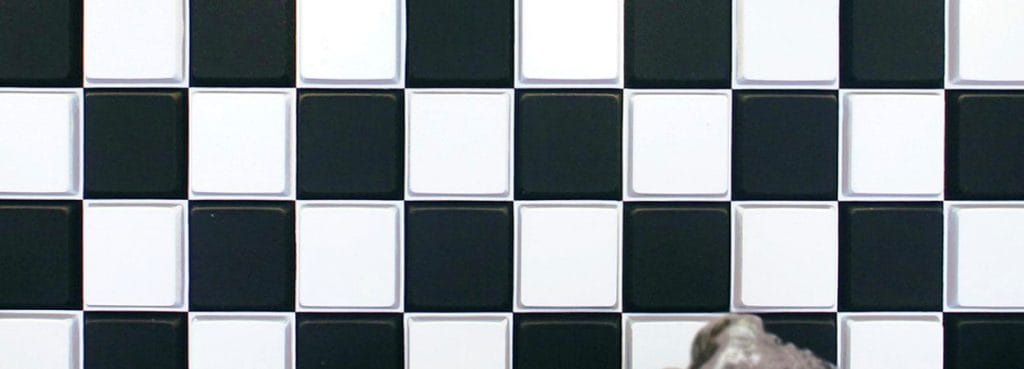 Ηχοαπορροφητικό πάνελ 3D Key Grid με ασπρόμαυρο μοτίβο σκακιέρας από ανάγλυφα τετράγωνα τσόχας για απορρόφηση του ήχου.