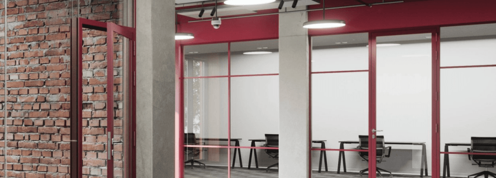 Πυράντοχο σύστημα Silence Loft σε σύγχρονο γραφείο, με κόκκινα πλαίσια μπροστά σε ρουστίκ τοίχο από τούβλα.