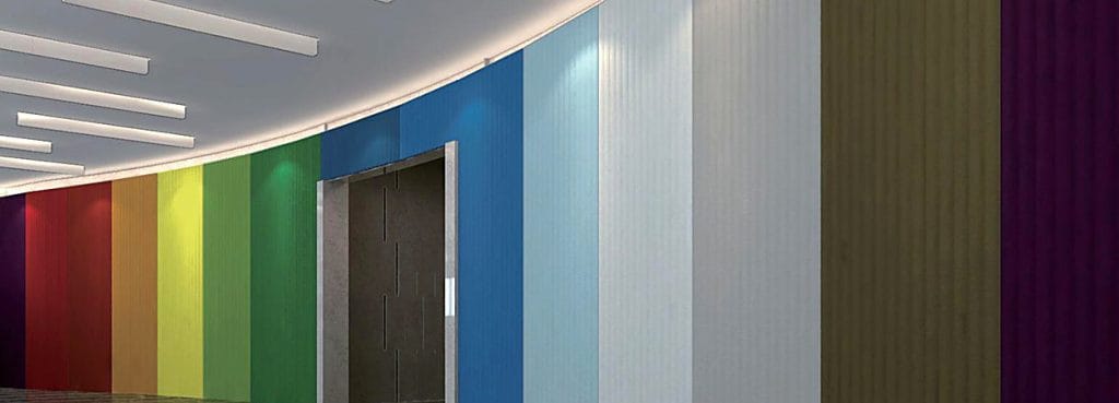 Ακουστικό πάνελ Valen Wave 75mm σε διάφορα ζωηρά χρώματα, τοποθετημένο σε καμπύλο τοίχο με απαλές κάθετες ραβδωτές υφές.